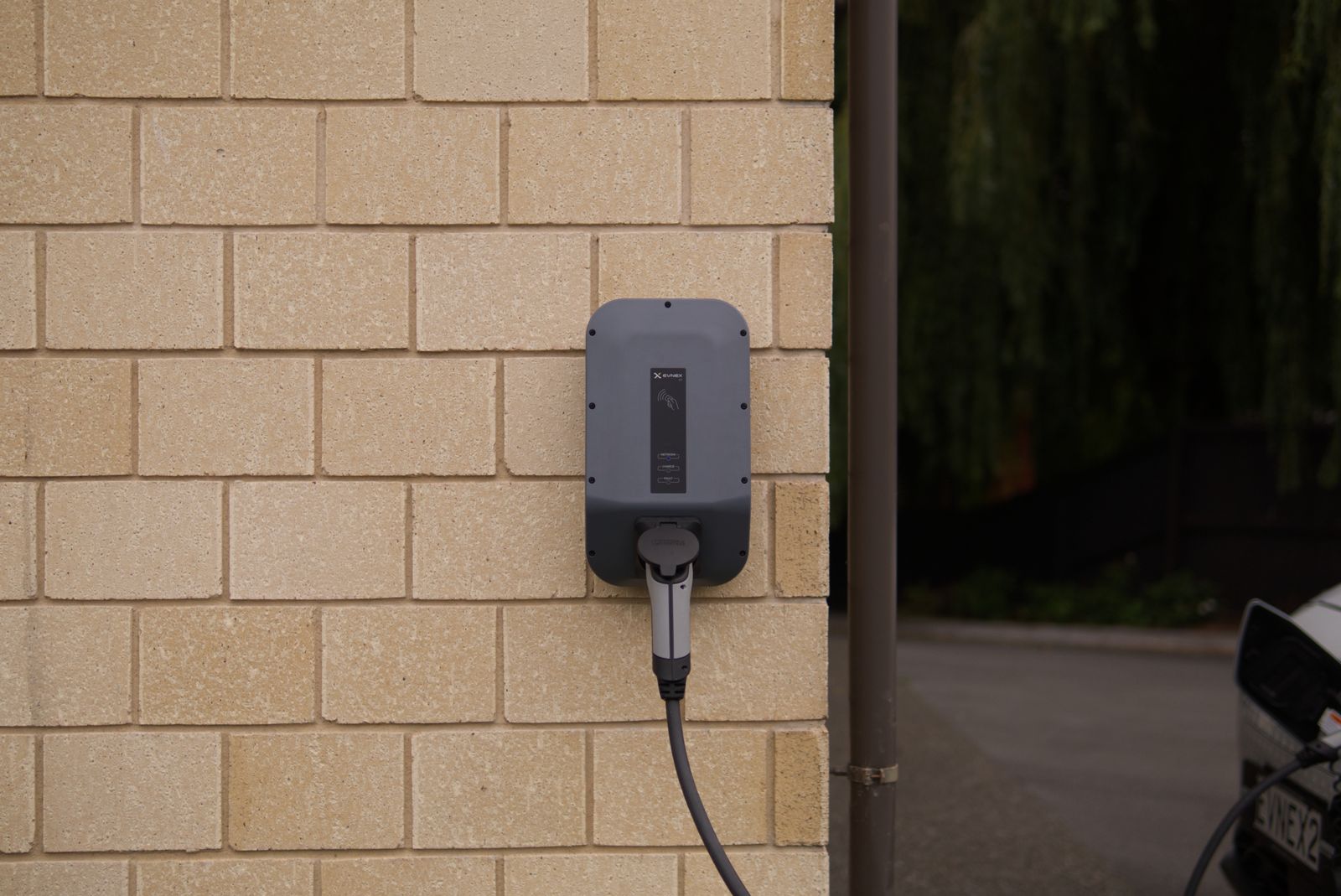 A wall mounted Level 2 electric vehicle charger installed in a garage