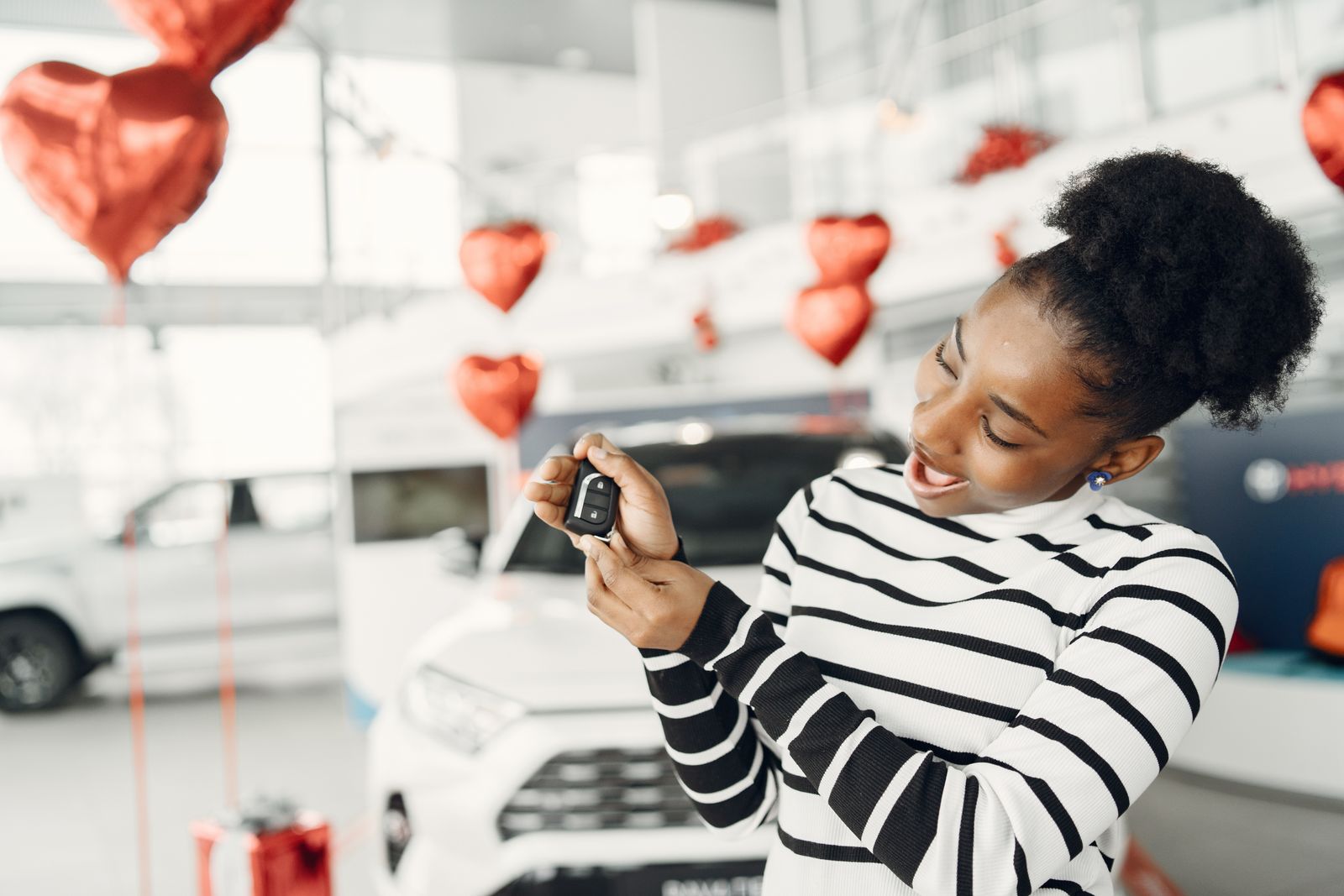 A customer holding car keys in a showroom